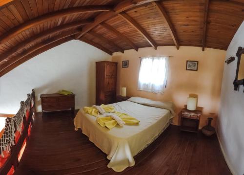 Un dormitorio con cama con toallas amarillas. en Casabosque Apartamentos en Las Gaviotas