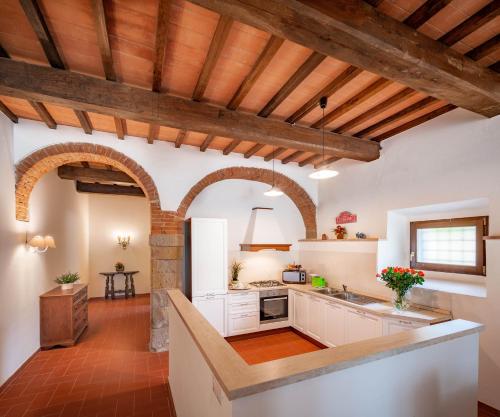 a kitchen with white cabinets and a wooden ceiling at Florence Country Residence in Vaglia