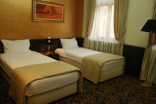 a hotel room with two beds and a window at Hotel Hercegovina in Sarajevo