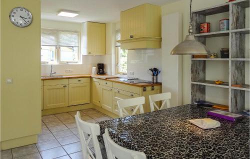a kitchen with a table and chairs and a clock at Oesterbaai 6 in Wemeldinge