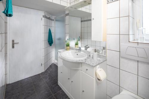 a white bathroom with a sink and a toilet at Landliebe in Uchte