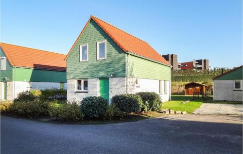 a green and white house with an orange roof at Oesterbaai in Wemeldinge