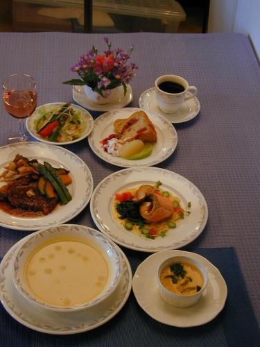 a table with plates of food and a cup of coffee at Pension Pure in Iiyama