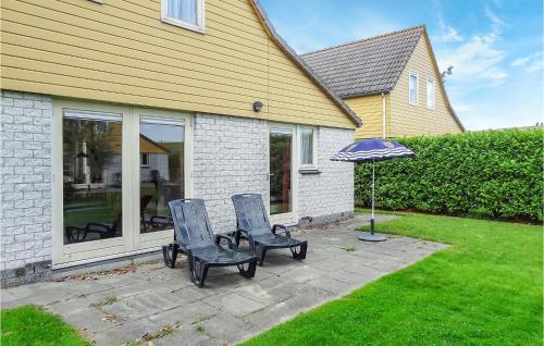 two chairs and an umbrella in front of a house at Oesterbaai 8 Personen in Wemeldinge