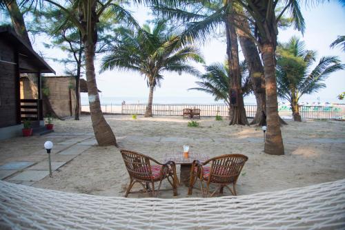 una mesa y sillas en una hamaca en la playa en Silent Beach Resort, en Mandrem
