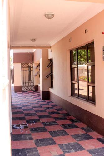 an empty hallway of a building with a checkered floor at Villa Prince in Harare
