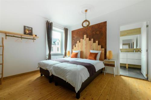 - une chambre avec un grand lit et une tête de lit en bois dans l'établissement Zythogite Appartement 9 personnes, jardin, bbq, à Tintigny