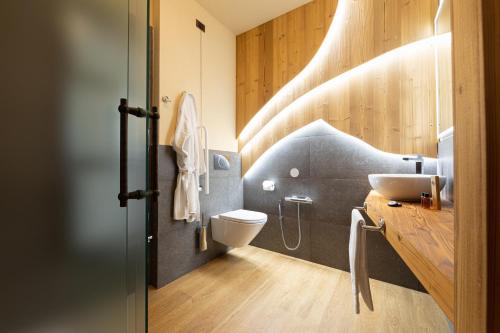 a bathroom with a sink and a toilet at Hotel Petit Tournalin in Champoluc