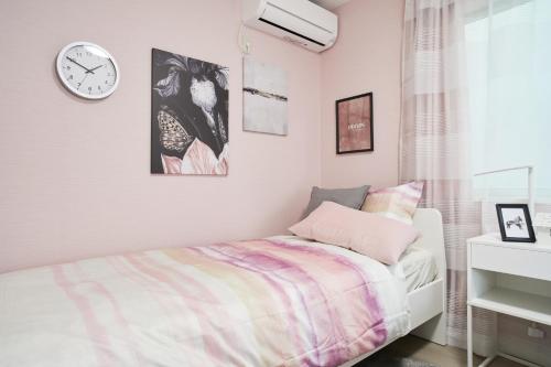 a bedroom with a bed and a clock on the wall at Beautiful Villa in Shinjuku Shin-OKubo 6minutes walk B in Tokyo