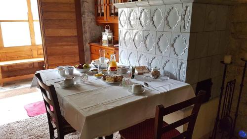 uma mesa numa cozinha com uma toalha de mesa branca em B&B ABETE BIANCO em Auronzo di Cadore