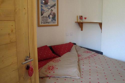 a bedroom with a bed with red pillows at val thorens appartement 4 personnes ski aux pieds in Val Thorens
