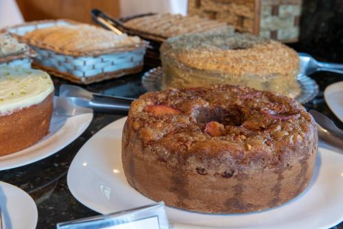 a bunch of cakes on plates on a table at Hotel Serra Everest in Nova Friburgo