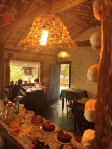 a dining room with a table with plates of food at Pousada Bangalôs Cipó in Serra do Cipo