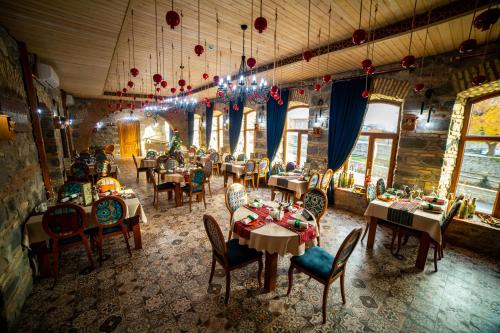 - un restaurant avec des tables et des chaises dans une salle dans l'établissement Old Town Sheki, à Shaki