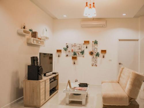 ein Wohnzimmer mit einer Couch, einem Sessel und einem Tisch in der Unterkunft U pool villa Huahin in Hua Hin