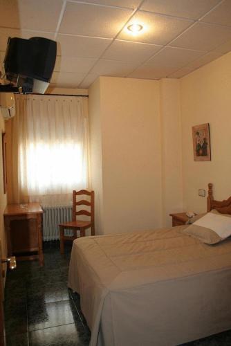 um quarto de hotel com uma cama e uma televisão em Parque em Cazorla