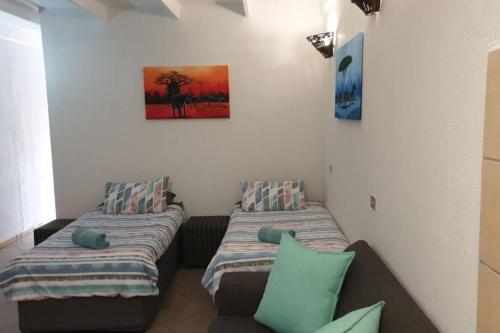 um quarto com duas camas e um sofá em 23 Manzini Chalets-Pumba's Den em St. Lucia