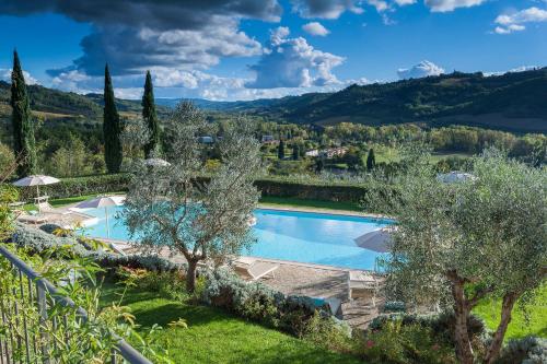a villa with a swimming pool and trees at Relais Poggio Borgoni in San Casciano in Val di Pesa