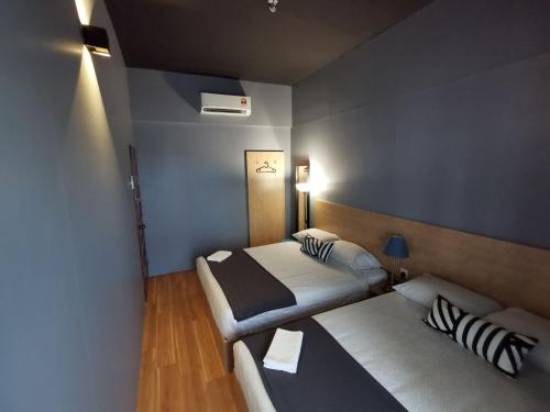 a small room with two beds and a couch at Tatami D'Tepi Laut - PANGKOR ISLAND in Pangkor