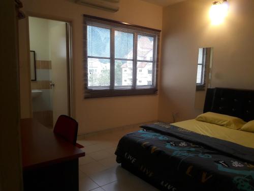 a bedroom with a bed and a window and a desk at Jeffrey Homestay Ipoh U @ Lost World of Tambun in Tambun