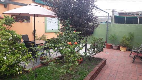 a patio with a table and an umbrella and plants at Montelife in Montevideo