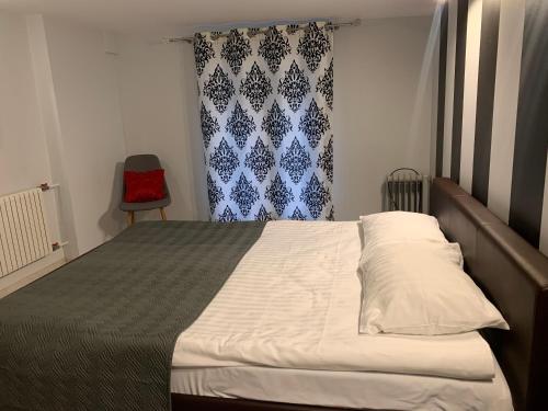 um quarto com uma cama e uma cadeira vermelha em Modern-style flat 2 em Riga