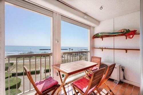 un tavolo e sedie su un balcone con vista sull'oceano di Vue mer à la plage du Môle - Clim - Fibre Wifi a Cap d'Agde