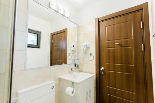 La salle de bains est pourvue d'un lavabo et d'une porte en bois. dans l'établissement Cedar Crest, à Râșnov
