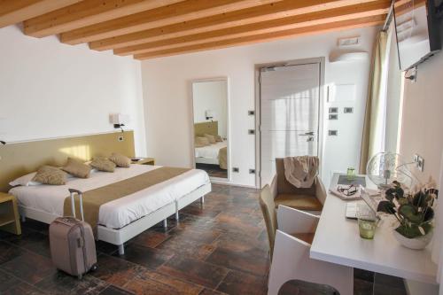 Habitación de hotel con cama, escritorio y habitación en Casanova Inn, en Martignacco