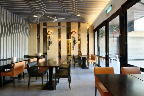 a dining room with tables and chairs and windows at Region Motel in Lugang