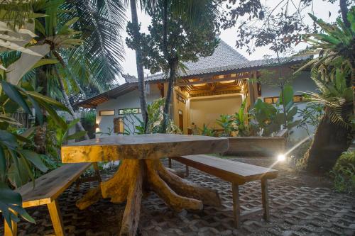 a wooden table and bench in front of a house at Adara Homestay in Banyuwangi