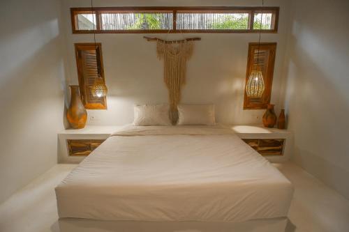 a bedroom with a white bed and a window at Adara Homestay in Banyuwangi