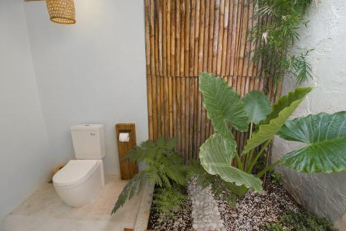 a bathroom with a toilet and some plants at Adara Homestay in Banyuwangi