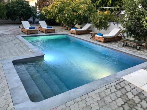an infinity pool with lounge chairs and a swimming pool at Villa Amor in Pefki Rhodes