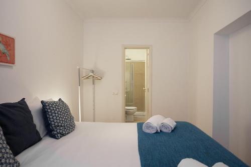リスボンにあるCozy Tailor Made With a Refreshing Terraceのベッドルーム1室(白いベッド1台、タオル2枚付)