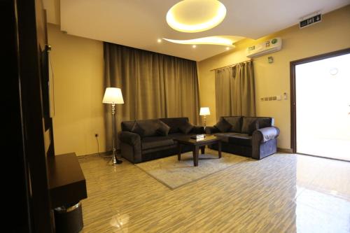 a living room with two couches and a table at شقق منازل الدانة للشقق المخدومة in Abha