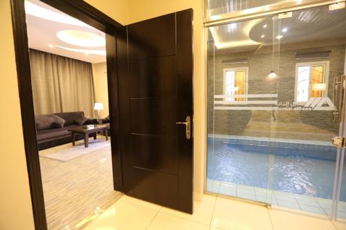 a door leading to a living room with a swimming pool at شقق منازل الدانة للشقق المخدومة in Abha