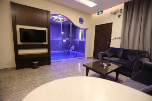 a living room with a couch and a tv at شقق منازل الدانة للشقق المخدومة in Abha
