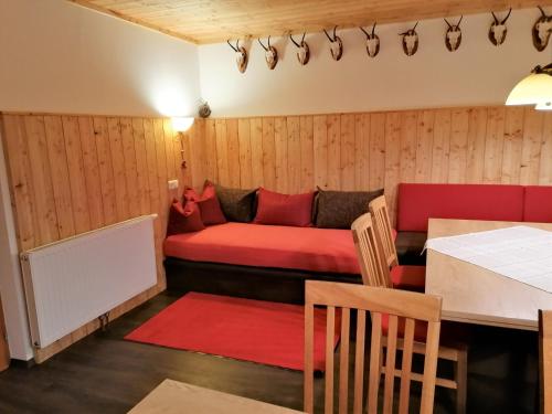 Habitación con sofá rojo y mesa. en Ferienhaus Sonnhof am Walchsee en Kössen