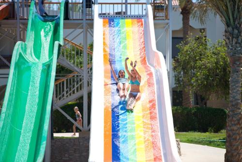 two girls on a rainbow slide at a water park at Amphoras Beach - Ultra All Inclusive in Sharm El Sheikh