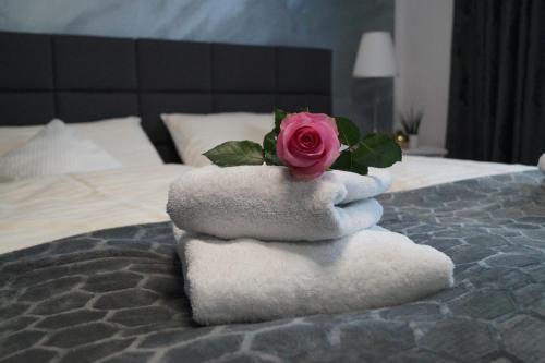 a rose on top of towels on a bed at Der Gutschmecker Bad Bramstedt in Bad Bramstedt