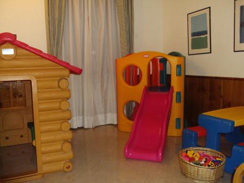 a childs play room with a slide and a play house at Hostellerie Le Lievre Amoureux in Valpelline