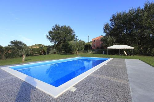 a swimming pool in a yard with an umbrella at Godere Agricolo in Penna Alta