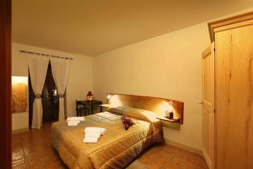 1 dormitorio con 1 cama con toallas en Godere Agricolo, en Penna Alta