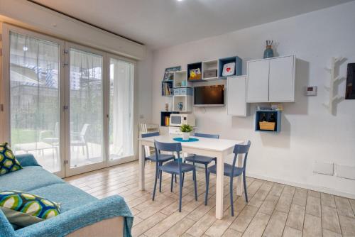 cocina y sala de estar con mesa y sillas en CaseOspitali - CASA AZZURRA incantevole bilocale con giardino, en Cernusco sul Naviglio
