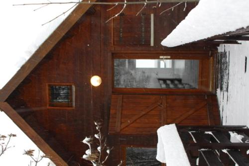 a wooden cabin with snow on the roof of it at Grand Chalet 15 personnes. Vue exceptionnelle . Plein sud in Allos