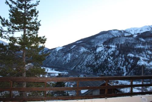 a view of a snow covered mountain with a wooden fence at Grand Chalet 15 personnes. Vue exceptionnelle . Plein sud in Allos
