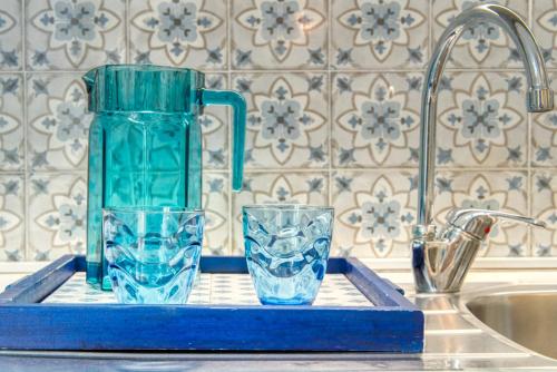 two glasses on a blue tray next to a sink at CaseOspitali - Casa Azzurra, incantevole bilocale con giardino in Cernusco sul Naviglio
