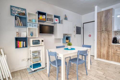 a dining room with a white table and chairs at CaseOspitali - Casa Azzurra, incantevole bilocale con giardino in Cernusco sul Naviglio