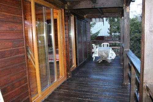 a porch of a wooden house with a chair at Grand Chalet 15 personnes. Vue exceptionnelle . Plein sud in Allos
